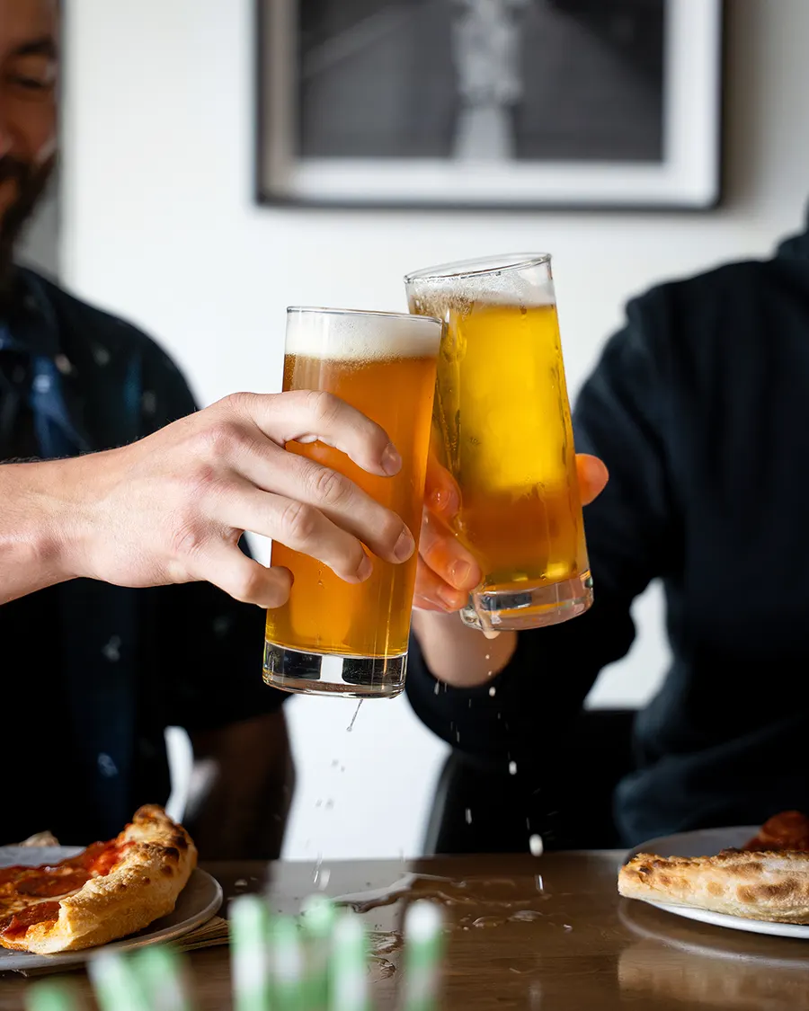 Cheersing cold local beers over slices