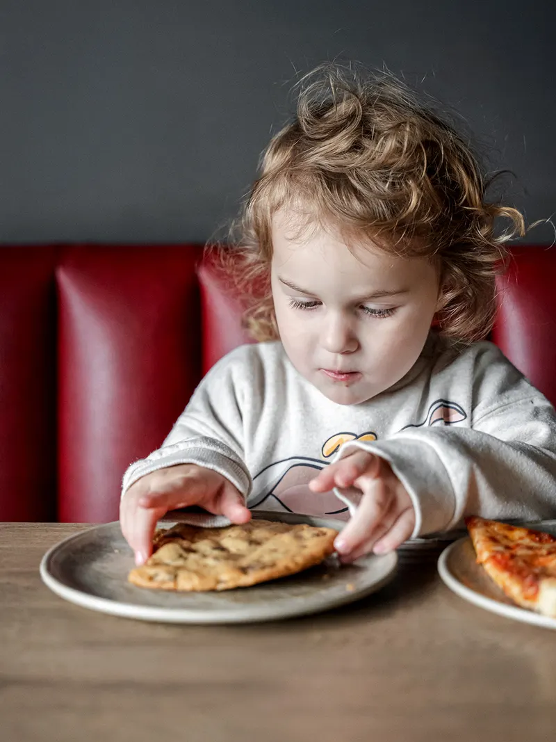 A young guest enjoying a slice in the booth